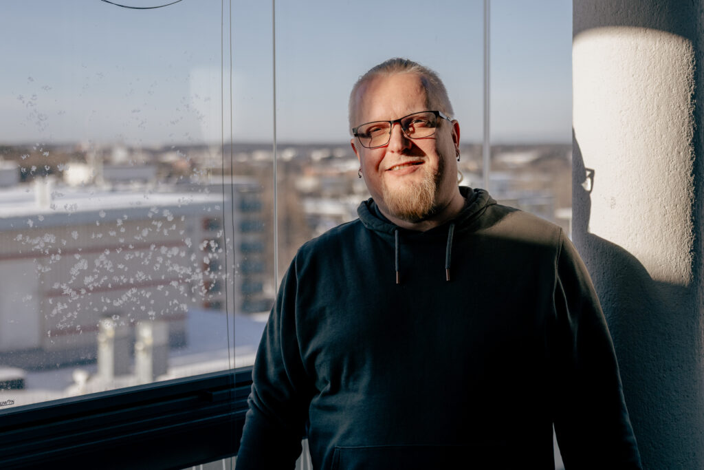 Kuva yrittäjästä. Vaaleahiuksinen mies, jolla on silmälasit. Taustalla näkyy kaupunkimaisema.